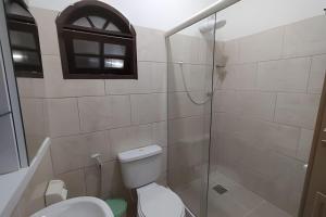 a bathroom with a toilet and a glass shower at Solares Boa Estada in Búzios +11 photos