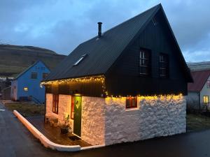 una casa con luci sul lato di Cozy traditional home, Syðrugøta a Syðrugøta