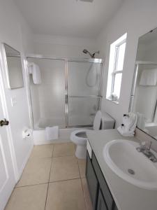 a bathroom with a shower and a toilet and a sink at Home from Home 5 bedroom villa in Davenport