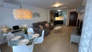 uma sala de estar com um sofá, uma mesa e cadeiras em Cómodo apartamento en El Palm mar em Palm-mar