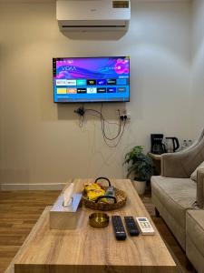 een woonkamer met een salontafel en een flatscreen-tv bij شقة فاخرة بدخول ذاتي 2 in Al Kharj