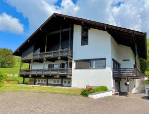 a large white building with a porch and balcony at Mountain Chalet Tre Marie in Cavalese