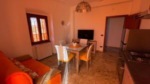 ein Wohnzimmer mit einem Tisch, Stühlen und einem Sofa in der Unterkunft Flowers & Angels Home in Santa Maria degli Angeli
