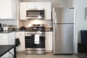 uma cozinha com um frigorífico de aço inoxidável e um fogão em Cozy Apt Near Midway Airport & Downtown em Chicago