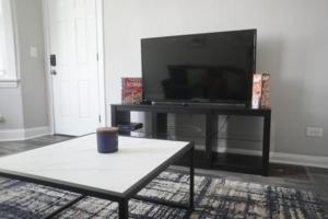 uma sala de estar com uma televisão e uma mesa de centro em Cozy Apt Near Midway Airport & Downtown em Chicago