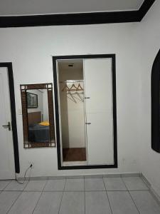 a white room with a mirror and a closet at Pousada - Aqui Hostel in Bragança Paulista