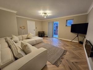 Una sala de estar con un sofá blanco y un televisor de pantalla plana. en New 2 Bedroom Appartment In Manchester - Stretford - Old Trafford Close to Football-Cricket Ground & City Centre, en Mánchester