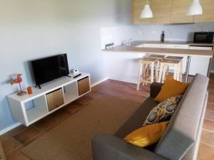 a living room with a couch and a tv at Casa da Encosta Chaves in Chaves