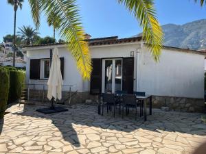 Un patio con mesa y sillas y una casa. en Bungalow en Denia, en Denia