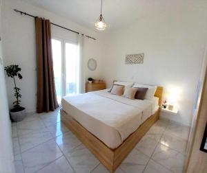 una camera da letto con un grande letto bianco e una finestra di 4T apartments ad Argostoli