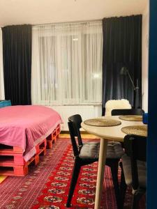 - une chambre avec un lit, une table et des chaises dans l'établissement Cosy studio in embassies area!, à Vilnius