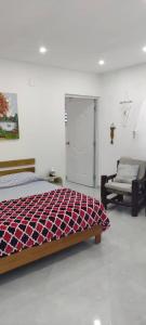 a bedroom with a bed and a door and a chair at Meridiana in Las Terrenas