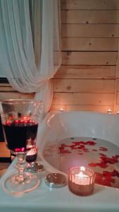 a bath tub with a glass of wine and a candle at Góralska Chata in Czarna Góra