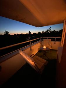 a balcony with a couch and a table on a roof at Appartement 59m2 professionnel ou familial Saint Quentin en Yvelines in Montigny-le-Bretonneux