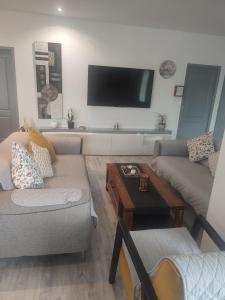 a living room with a couch and a coffee table at Charmante maison près du Futuroscope in Saint-Georges-lès-Baillargeaux