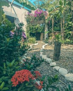 un jardín con flores y un camino de piedra en Palomino EcoHouse & Camping en Palomino