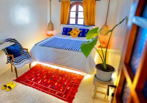 a bedroom with a bed and a potted plant at Dar Zohra-At the door of Africa. in Tangier