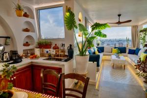 een keuken en een woonkamer met een bank en planten bij Dar Zohra-At the door of Africa. in Tanger