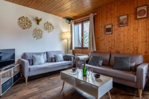 a living room with two couches and a table at Grand Appartement dans Chalet Serre Chevalier à 8 minutes des pistes in Saint-Chaffrey
