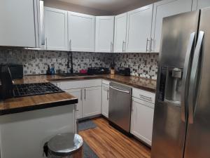 a kitchen with white cabinets and stainless steel appliances at Great large home,8 min from Downtown in Pensacola