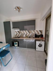 una cucina con piano cottura e lavatrice di Le Carla studio 2 personne a Nizza