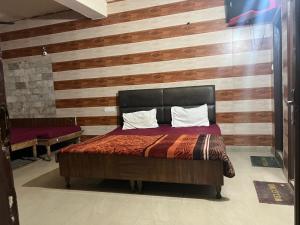 a bedroom with a bed with a wooden wall at Hotel Skylark in Amritsar