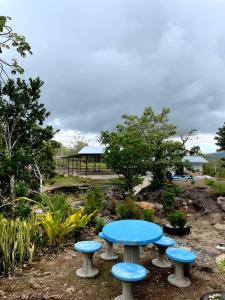 Ein blauer Tisch und vier Hocker in einem Garten in der Unterkunft Miravalles Volcano House in Guayabal