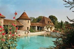 an estate with a swimming pool in front of a house at Les gites et chambres d'hôtes du Mas de bouzou in Grèzes