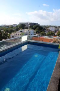 een groot zwembad op het dak van een gebouw bij Mini Rooms By Illusion in Playa del Carmen