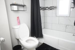 uma casa de banho com um WC, uma banheira e um lavatório. em Cozy Apt Near Midway Airport & Downtown em Chicago