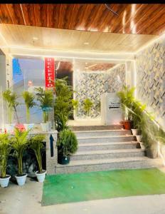 a lobby with stairs and potted plants at Plazzo Prime Plaza in New Delhi