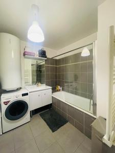 a kitchen with a washing machine and a bath tub at La Chambre in Saint-Denis