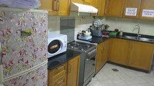 a kitchen with a stove top oven next to a refrigerator at Ruby Star Male Hostel Dubai in Dubai