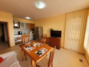 Una sala de estar con mesa de comedor y una cocina. en Laguna Alba Apartment, en Kavarna