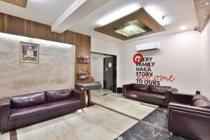 una sala de espera con sofás de cuero y un cartel en la pared en Collection O Hotel Kia Residency, en Bodakdev
