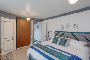 Un dormitorio con una cama azul y blanca y una puerta en Casa Amatlán Ciento Dos, en Ciudad de México