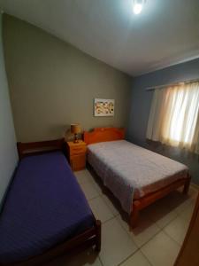 um quarto com 2 camas e uma janela em tranquilidade em Serra Negra