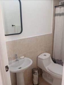 ein Badezimmer mit einem Waschbecken, einem WC und einem Spiegel in der Unterkunft Eco terra in Chalchuapa