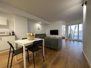 ein Wohnzimmer mit Tisch und Stühlen und einer Couch in der Unterkunft Apartamentos Canet al Mar. in Canet d'en Berenguer