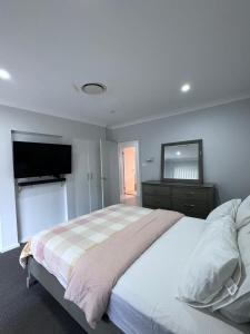 a bedroom with a large bed and a flat screen tv at Modern Luxury with Nature in Camden
