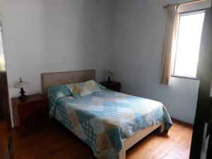 ein Schlafzimmer mit einem Bett mit einer Decke darauf in der Unterkunft Global Family Backpackers Hostel in Lima