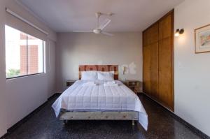 a bedroom with a bed and a large window at Spacious Apartment Located In Downtonwn Asuncin in Asunción