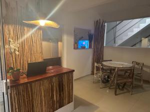 a office with a desk and a table with a laptop at Pousada Linda Flor in Morro de São Paulo