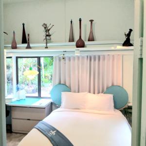 een slaapkamer met een bed, een bureau en een raam bij Unique Art & Nature Hideaway Walk to Wilton Drive in Fort Lauderdale