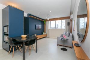 a living room with a table and a blue wall at Confortável Studio com 46,72m² in Florianópolis