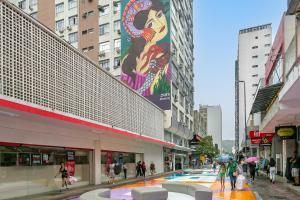 a group of people walking down a street in a city at Confortável Studio com 46,72m² in Florianópolis
