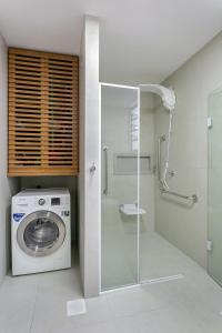 a washing machine in a bathroom with a shower at Confortável Studio com 46,72m² in Florianópolis +11 photos