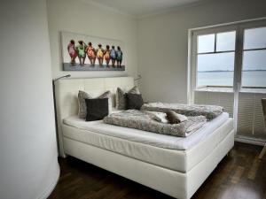une chambre avec un lit avec un tableau sur le mur dans l'établissement Ferienhaus-Sliminde-by-Seeblick-Ferien-direkte-Wasserlage-E-Ladesaeule-Sauna, à Olpenitz