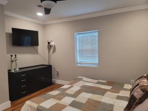 a bedroom with a bed and a flat screen tv at Great large home,8 min from Downtown in Pensacola