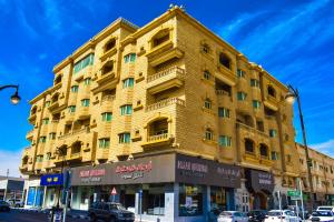 um grande edifício amarelo na esquina de uma rua em ارجان قرطبة للشقق المخدومة em Al Khobar